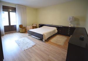 a bedroom with a bed and a dresser and a window at La casa de El Burgo in El Burgo de Osma