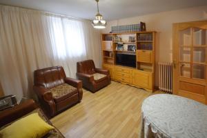 uma sala de estar com duas cadeiras e uma televisão em La casa de El Burgo em El Burgo de Osma