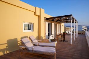 una terraza con sillas y una pérgola en una casa en Doma Hotel, en La Canea