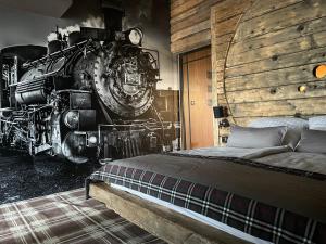a bedroom with a steam train and a bed in it at Ostoja Spokoju in Olchowiec