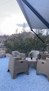 a group of chairs and an umbrella on a beach at كرفان الياسمين in Al Hada