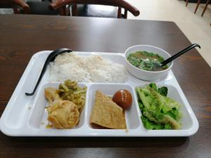 uma bandeja de comida com brócolos de arroz e uma tigela de sopa em Udara's Colombo Rooms em Battaramulla