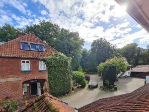 a large brick house with a courtyard in front of it at Pension & Ferienhof Glüß in Lünzen