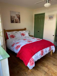 a bedroom with a bed with a red blanket on it at Stable Cottage, Bishops Castle in Bishops Castle