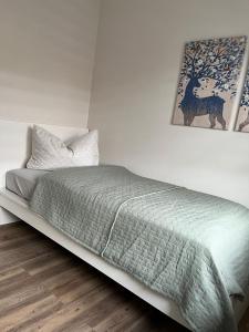 a bed with a green comforter in a bedroom at Loft am See in Dargun