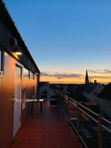 ハウゲスンにあるFlotmyrgården Apartment Hotelの- 夕日の街の景色を望むバルコニー