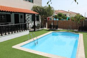 a swimming pool in a yard next to a house at Hostel Casa Lucas in Charneca