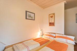 a bedroom with two beds and a lamp on the wall at Haus Rosi und Werner in Emmerting