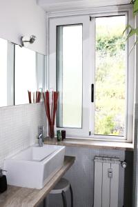 a bathroom with a white sink and two windows at Gallery Guesthouse in Rome +30 photos
