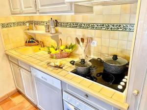 a kitchen counter with pots and pans on a stove at Chez Camille in Saint-Tropez +8 photos