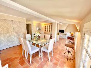 a dining room with a glass table and white chairs at Chez Camille in Saint-Tropez