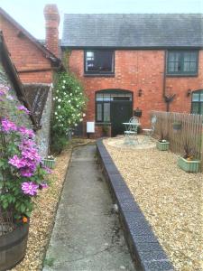 a garden in front of a brick house at Stable Cottage, Bishops Castle in Bishops Castle