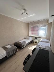 a room with two beds and a window at Kwatery prywatne Jaśmin in Gniezno