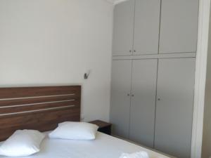 1 dormitorio con 1 cama con 2 almohadas blancas en Market, en Korinthos