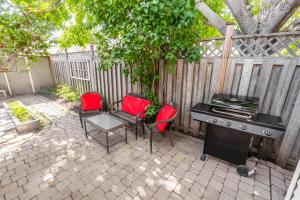 a patio with chairs and a grill and a fence at Cozy 5 Bedroom House in Downtown Toronto by GLOBALSTAY in Toronto