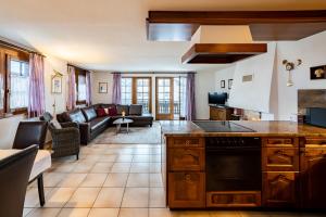 uma cozinha e sala de estar com um sofá em Haus Zer Weidu em Zermatt