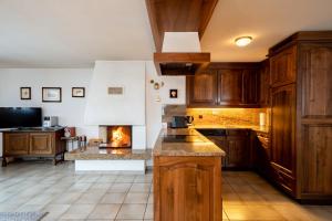 a kitchen with wooden cabinets and a fireplace at Haus Zer Weidu in Zermatt