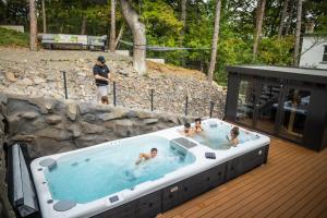a group of people in a hot tub on a deck at 4 Évszak Erdeihotel**** - Mátrafüred in Mátrafüred +116 photos