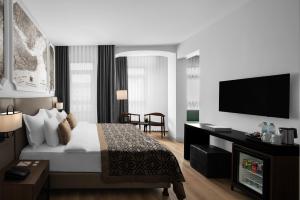 a hotel room with a bed and a flat screen tv at Akka Suites Taksim-Special Class in Istanbul