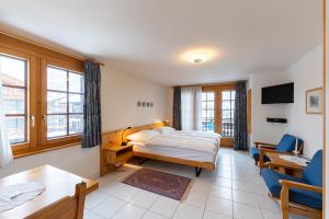 Habitación de hotel con cama, mesa y sillas en Haus Zer Weidu, en Zermatt