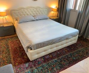 a bed in a bedroom with two lamps and a rug at Suite Falier- Luminosa Venezia in Venice