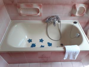 a bath tub with a shower in a pink bathroom at Casa le rondini in Mezzenile