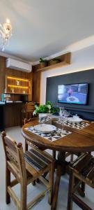 a dining room with a table and a tv at Apartamento Climatizado Familiar NOVO Ed Lírio do Vale Próx ao Termas de Piratuba SC in Piratuba