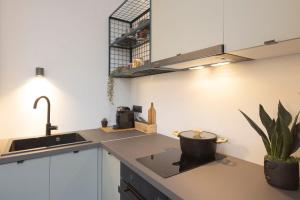 a kitchen with white cabinets and a sink and a plant at K4 0 City Apartments, Historical Center, Thessaloniki #FeelsLikeHome in Thessaloniki