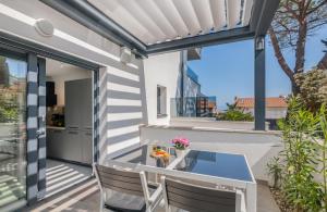 a patio with a table and chairs on a balcony at Apartments Elle Luxury Vantačići in Malinska