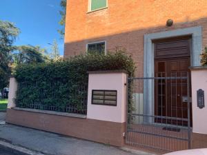 ein Backsteinhaus mit einem Zaun und einer Tür in der Unterkunft Casa di Vanessa in Bologna