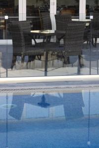 
a pool with chairs and tables in it at Livadia Hotel Kyperounta in Kyperounda
