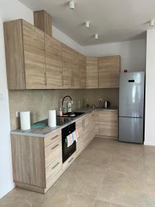 uma cozinha com armários de madeira e um frigorífico de aço inoxidável em Apartament w Centrum em Sokólka
