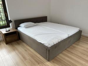 duże łóżko w sypialni z drewnianą podłogą w obiekcie Apartament w Centrum w mieście Sokółka