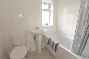 a white bathroom with a toilet and a sink at Alderton House - Spacious 3 Bed with Parking in Nottingham