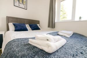 a bedroom with a bed with white towels on it at Alderton House - Spacious 3 Bed with Parking in Nottingham