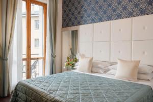 a bedroom with a large bed and a window at Hotel Re Enzo in Bologna