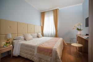 um quarto de hotel com uma cama grande e uma mesa em Hotel Re Enzo em Bolonha