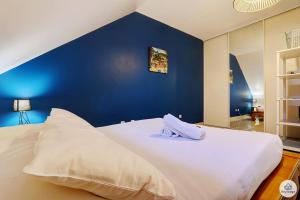 a large white bed with a blue wall at Amarena - 37m2 - Boucan Canot in Saint-Gilles les Bains