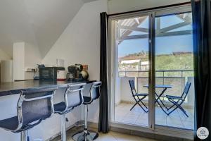 a kitchen with a table and chairs and a balcony at Amarena - 37m2 - Boucan Canot in Saint-Gilles les Bains