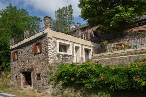 an old stone building with a balcony on top of it at Gîte de la Moulinquié in Saint-Cirgue