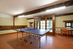 a ping pong table in the middle of a room at Gîte de la Moulinquié in Saint-Cirgue