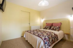 a bedroom with a large bed with pink pillows at Gîte de la Moulinquié in Saint-Cirgue