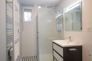 a white bathroom with a sink and a shower at Gîte de la Moulinquié in Saint-Cirgue +4 photos