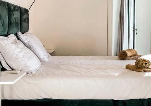 a white bed with two teddy bears on it at Ibiza style bungalows with sea views in Balzi Rossi in Ventimiglia