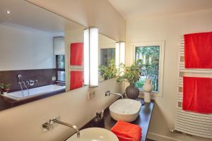een badkamer met 2 wastafels en een spiegel bij LA PORTE ROUGE RBX in Roubaix