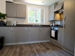a kitchen with white cabinets and a window at Pass the Keys Modern Well Located New Build Apartment in Birmingham