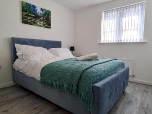 a bedroom with a large bed with a green blanket at Pass the Keys Modern Well Located New Build Apartment in Birmingham