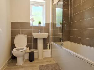 a bathroom with a toilet and a sink and a tub at Pass the Keys Modern Well Located New Build Apartment in Birmingham