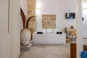 Corte Janca في Montesano Salentino: حمام مع حوض أبيض و مزهرية