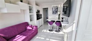ニースにあるAffitto-Nizzaの紫色のソファとテーブル付きのリビングルーム